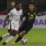 Kapten Persebaya Rachmat Irianto (kanan) mengawal pemain Persipura Elisa Basna dalam lanjutan Liga 1 2021-2022. (Riana Setiawan/Jawa Pos)