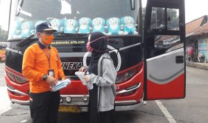 MISI KEMANUSIAN: Kepala Pelaksana BPBD Provinsi Jawa Barat Dani Ramdan, saat membagikan masker kepada calon penumpang bus di Terminal Cicaheum, Kota Bandung, Sabtu (19/2).