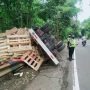 Petugas Kepolisian saat mengamankan lalu lintas pasca kecelakaan tunggal yang menimpa satu unit truk diesel di Jalan Raya Bandung-Cirebon telatnya di area Cadas Pangeran, Kabupaten Sumedang
