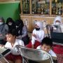 Murid SDN 7 Rancaekek, terpaksa belajar dengan beralaskan tikar, karena kursi dan meja belajar mereka tersapu banjir bandang beberapa waktu lalu.