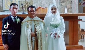 Tangkapan layar unggahan video yang menunjukkan prosesi pemberkatan yang dilakukan wanita berhijab bersama pasangannya di gereja.