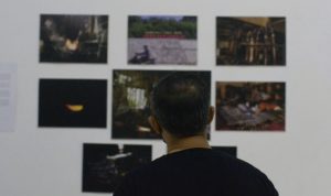 Pengunjung melihat foto yang dipajang pada Pameran Fotografi Arus Waktu di Dermond, Jalan Sumbawa, Bandung, Rabu (23/3). (Dok. Dimas Rachmatsyah)