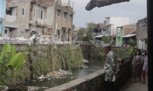 BANTARAN SUNGAI: Seorang warga tengah memperhatikan aliran sungai di Cikapundung Kolot, Kelurahan Gumuruh, Kecamatan Batununggal, Kota Bandung. (Deni/Jabar Ekspres)