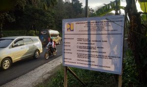 papan proyek pengerjaan perbaikan jalan di malam hari kemungkinan agar arus lalu lintas dan angkutan logistik tidak tergangu.