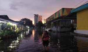 Pasar Gedebage Kebanjiran, Kolam Retensi Masih Belum Bisa Mencegahnya BANJIR: Seorang ibu menggendong sang anak di tengah genangan banjir yang melanda di wilayah Pasar Induk Gedebage, Selasa (6/4) sore.