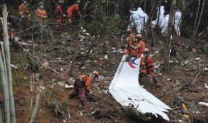 Pekerja mencari melalui puing-puing di lokasi pesawat China Eastren jatuh (Foto: Xinhua News Agency)