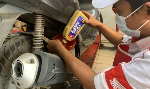 Mekanik AHASS melakukan penggantian oli sepeda motor Honda menggunakan AHM OIL kemasan terbaru.