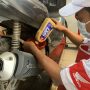 Mekanik AHASS melakukan penggantian oli sepeda motor Honda menggunakan AHM OIL kemasan terbaru.