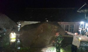 Petugas menunjukkan Bongkahan batu sebesar mobil yang menimpa rumah warga, saat akan di evakuasi. (ANTARA/HO-istimewa)
