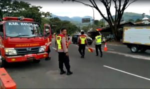 Akses Jalur Lingkar Nagreg Licin Akibat Bahan Bakar Solar Tumpah Tangkapan layar video: Petugas Damkar membersihkan tumpahan solar dan dibantu anggota Polisi untuk mengatur arus lalu lintas di Lingkar Barat Nagreg.