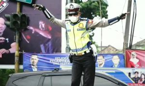 HIBUR PENGENDARA: Aipda Tatang Wiguna, anggota polisi Satlantas Polres Cimahi memperlihatkan aksi joget sambil mengatur lalu lintas. Hal tersebut dilakukan untuk menghibur para kendara yang melintas.