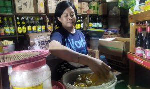 Pedagang Minyak Goreng Khawatir KTP-nya Disalahgunakan KHAWATIR: Penjual minyak, Lilis Wastiah, (42), tengah merapikan barang dagangan di kiosnya, di Pasar Kiaracondong, Kota Bandung, Selasa (28/6). (Nizar/Jabar Ekspres)