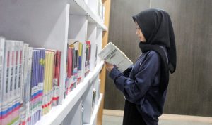 Seorang wanita tengah menikmati manfaat fasilitas literasi milik Dispusipda Jabar. (Deni/Jabar Ekspres)