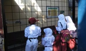 Beberapa siswa di Bandung terlantar didepan pagar sekolah, karena tidak bisa memasuki area sekolahnya. [Suara.com/Ferrye Bangkit R]