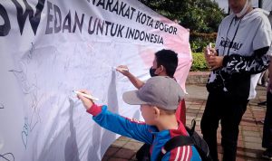 Jarnas Beraksi Jabar membentangkan spanduk yang ditanda tangani oleh para pendukung Capres Anies Baswedan di Lapangan Sempur, Kota Bogor, Minggu (9/10). (Yudha Prananda / Jabar Ekspres)