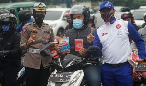 Pemberian buku pedoman keselamatan berlalu lintas oleh Safety Riding Development Section Head PT Daya Adicipta Motora, Ludhy Kusuma dan Kompol Iis Diana.