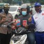 Pemberian buku pedoman keselamatan berlalu lintas oleh Safety Riding Development Section Head PT Daya Adicipta Motora, Ludhy Kusuma dan Kompol Iis Diana.