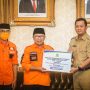 PEDULI KORBAN:Sekda Ema Sumarna, saat menyerahkan bantuan kepada Bupati Cianjur, Herman Suherman di Pendopo Kabupaten Cianjur, Senin 28 November 2022.