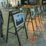 Seorang pengunjung pameran tengah menyimak foto jurnalistik hasil karya anggota WFB. (KHOLID/JABAR EKSPRES)