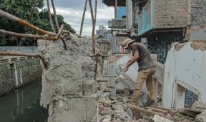 BUTUH BELAS KASIH: Seorang warga Kelurahan Maleer, Kecamatan Batununggal, Kota Bandung tengah mengambil bahan bangunan yang tersisa usai penggusiran rumah oleh Satgas Citarum Harum. (KHOLID/JABAR EKSPRES)