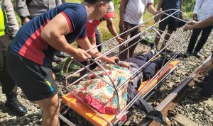 Warga bersama petugas saat mengevakuasi korban meninggal dunia di perlintasan kereta api Pondok Rajeg, Kabupaten Bogor. (Sandika Fadilah via Polsek Cibinong)