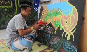 Aam Jamaludin saat membuat kaligrafi di rumahnya, Kelurahan Cicaheum, Kiaracondong, Kota Bandung. (HENDRIK MUCHLISON/JABAR EKSPRES)