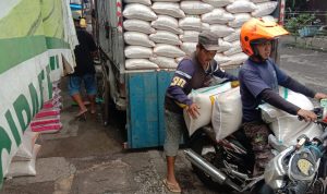 Salah seorang tengah memindahkan karung beras untuk ketersediaan di Bandung. (SANDI NUGRAHA/JABAR EKSPRES)