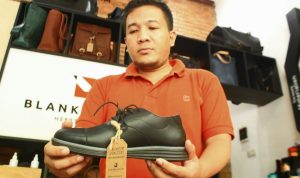 Beny Ramdany Sofara menunjukkan produk sepatu unggulannya / Hendrik Muchlison