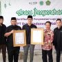 Kabid Verifikasi dan Penilaian Produk Halal BPJPH Kemenag RI, Cecep Kosasih saat memberikan bingkai Sertifikat Halal kepada CEO Esteh Indonesia, Haidhar Wurjanto, Kamis (30/3) di Main Office Esteh Indonesia, Kota Bogor. (Yudha Prananda / Jabar Ekspres)