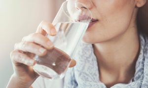 Begini Caranya Agar Cairan Tubuhmu Tahan Saat Berpuasa! Potret wanita sedang mengonsumsi air putih