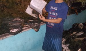 Seorang santri Ponpes Nurul Hidayah saat menunjukkan sejumlah kitab yang ikut terbakar. (istimewa)