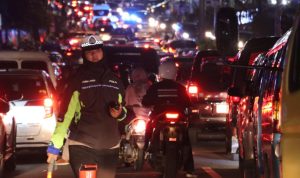 Petugas kepolisian saat mengatur lalulintas di jalan raya puncak, Kabupaten Bogor.
