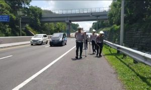 BERSIHKAN JALAN: Sejumlah personel Satlantas Polres Cimahi menyisir bahu jalan di sepanjang jalur mudik di ruas Tol Purbaleunyi untuk menyisir ranjau paku yang berserakan.