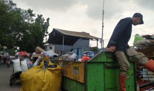 Petugas Kebersihan di TPS Pagarsih dengan tumpukan sampah yang masih berada di roda akibat kekurangan armada pengangkut sampah untuk dibawa ke TPA Sarimukti. Foto: Akmal Firmansyah/Jabarekspres.