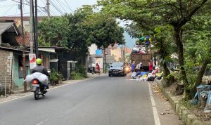 Petugas tengah menangkut sampah yang meluber ke badan jalan di Cimahi Tengah, Kota Cimahi. (Foto Cecep Herdi/Jabar Ekspres)