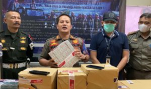 Kepala Bidang Penegakan Perda Satpol PP Kota Cimahi Ranto Sitanggang memegang rokok ilegal yang disita dari tokok kelontongan di wilayah Padasuka Kota Cimahi, Senin (12/6).