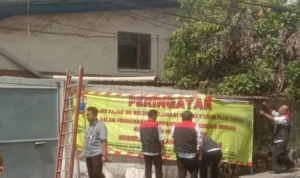 Bapenda dan Kejari Kota Cimahi memberikan peringatan terkait wajib pajak yang menunggak pembayaran melalui spanduk dan stiker besar. Jabar Ekspres/Cecep Herdi.