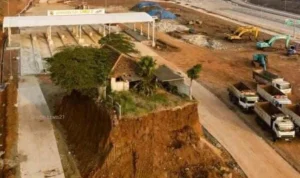 Sebuah rumah dilokasi proyek Jalan Tol Cijago (Cinere Jagoraawi-Limo) Seksi 3B tegak berdiri di tengah gerbang masuk pintu tol di Depok.