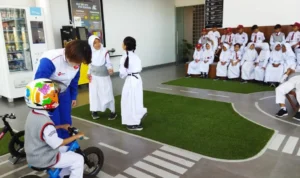 Instruktur Safety Riding DAM, Nofa Ismiati & Tamy Pratama memberikan edukasi keselamatan berkendara untuk siswa-siswi Sekolah Dasar Negeri 061 Cijerah Kota Bandung pada sesi praktek di area kids park Safety Riding Center DAM.