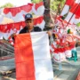 Rehan alias Ubek (33) sedang memegang bendera Merah Putih di lapak tempatnya berjualan di Sumedang, Jum'at 4 Agustus 2023.
