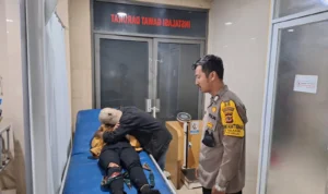 Kejahatan Malam di Sukabumi, Lutut Korban Robek Akibat Sajam Anggota Bhabinkamtibmas Polsek Sukabumi (kanan) saat mengecek kondisi korban.