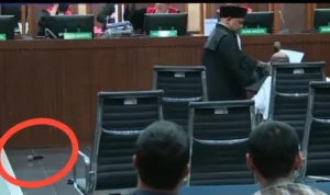Tangkapan layar video Lukas Enembe lempar mik saat sidang kasus korupsi yang menjeratnya di persidangan Tipikor, Senin (4/9). (Youtube)