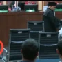 Tangkapan layar video Lukas Enembe lempar mik saat sidang kasus korupsi yang menjeratnya di persidangan Tipikor, Senin (4/9). (Youtube)