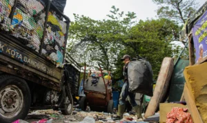 Masa Darurat Sampah Diperpanjang, Ini Penjelasan Pj Wali Kota Bandung Petugas kebersihan tengah mengangkut kantong besar berisi sampah di TPS Cijambe, Kota Bandung. (Pandu Muslim/Jabarekspres)