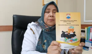 Kepala Dinas Lingkungan Hidup Kota Banjar Chanifah Listyarini menunjukkan pedoman Peraturan Daerah (Perda) Kota Cimahi Nomor 6 Tahun 2019 Tentang Penyelengaraan Pengelolaan Sampah. (foto: Cecep Herdi/Jabar Ekspres)
