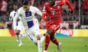 Alphonso Davies (baju merah) saat melewati lawannya.