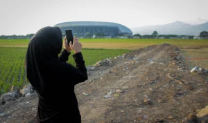 Belum Beres, TPS Darurat di Gedebage Masuk Tahap Pematangan Seorang warga mengabadikan momen di sekitaran TPS Darurat Gedebage di Kelurahan Rancanumpang, Gedebage, Kota Bandung. (Pandu/Jabarekspres)