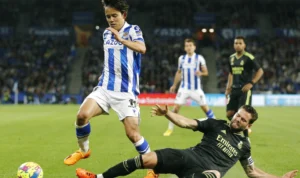 Takefusa Kubo (Biru Putih) saat berhadapan dengan mantan rekan setim di Real Madrid, Nacho Fernandez (Hitam)