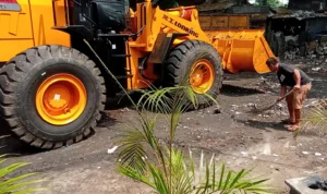 Warga membersihkan sisa sampah di salah satu TPS Kota Bandung yang meluber hingga ke jalan.
