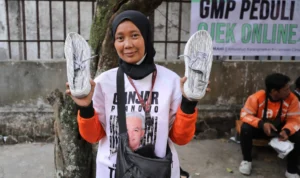 Salah seorang drivel ojol menunjukkan pembagian sepatu gratis dari dari Ganjar Muda.